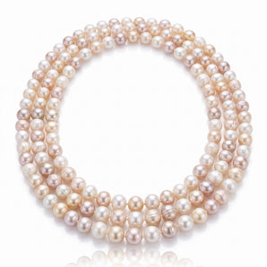 A multi-strand pearl necklace composed of round, lustrous pearls in soft champagne, blush, and cream tones.