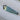 A faceted custom-cut teal sapphire with a gradient color shifting from light mint green to deep teal blue.