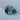 A pear-cut parti sapphire with a faceted teal-blue and dark gray-green color