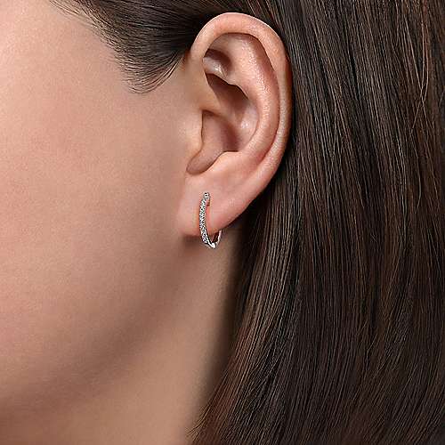 Gabriel & Co. 14K White Gold Classic Style Huggies on a woman's ear