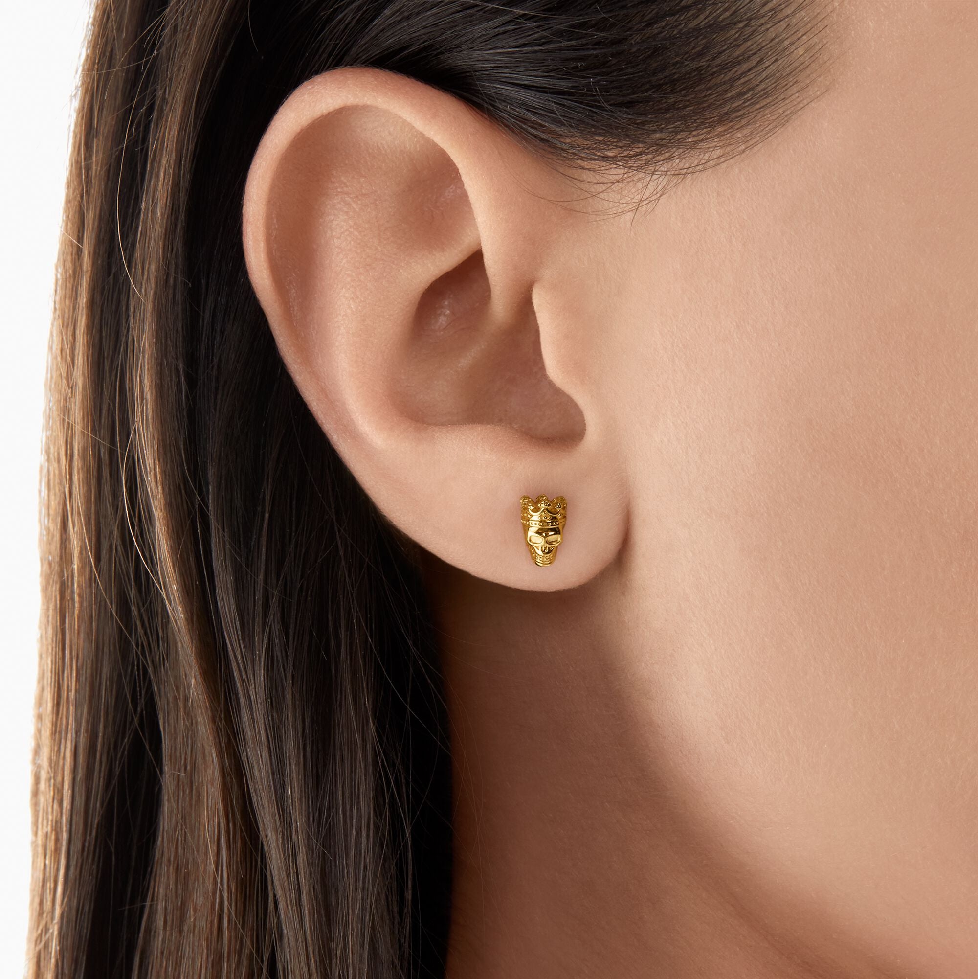 Thomas Sabo 18k Gold Plated Skull Ear Studs on a woman's ear